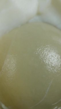 Dikey video. İçinde yumurta sarısı olan yarım haşlanmış yumurta. Macro Zoom. - Dolly. Siyah bir Arkaplanda.