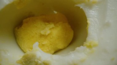 Siyah arka planda haşlanmış tavuk yumurtası, doğranmış parçalar arasında doli. Yakın plan..