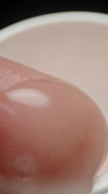 Dikey video. Erkeklerin parmakları, ihmal edilen el derisine krem sürerler. Yakın plan..