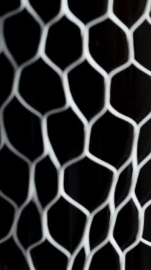 Dikey video. Bir adamın eli şarap şişesinden beyaz koruyucu ağı çıkarır. Yakın plan..