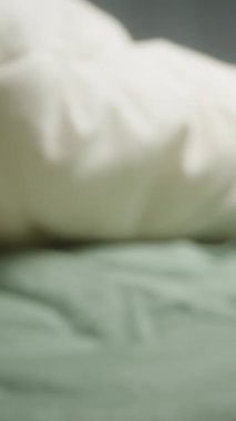 Dikey video. Yatak ve Yastığın Arkaplanına Karşı El Dişi. Yakın plan Dolly. Yavaş Hareket.