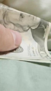 Dikey video. Yastığın Altındaki 20 Dolarlık Diş Perisi Yerleri ve Diş Takıyor. Birinci şahıs Dolly. Yakın plan..