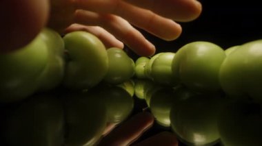 Siyah Masadaki Olgunlaşmamış Yeşil Kiraz Erikleri, Dolly Kaydırıcı Aşırı Yakın plan. El onları toplar..