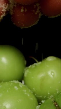 Dikey video. Taze kiraz eriklerine tuz serpme, yavaş hareket. Dolly Kaydırıcı, yakın plan..