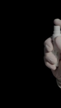Dikey video. Beyaz Eldivenli Doktor 'un Elleri, onlara antiseptik sıkın. Virüs Koruma. Siyah Arkaplanda Yavaş Hareket.