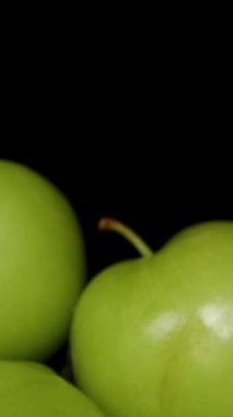 Dikey video. Kasedeki Yeşil Erik Yığını 'nı. Kara Arkaplan 'da izole edilmiş. Dolly Kaydırıcı, yakın plan..