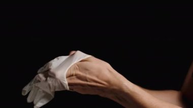 Beyaz lateks eldivenleri takan kadın eli, doktor muayeneye hazırlanıyor. Kara Arkaplanda İzole Edilmiş.