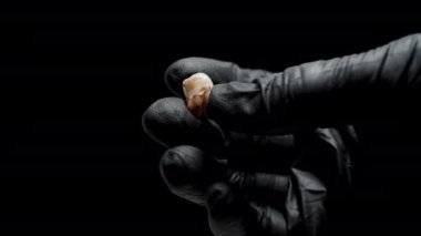 Siyah Eldivenli Eller Küçük Paket İçinde Kan İçinde Bir İnsan Dişi Toplar. Suç Mahalli Kanıtı kavramı..