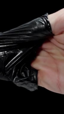 Dikey video. Bir doktor terden sırılsıklam olmuş siyah eldivenleri çıkartır, doktorların zor işleri kavramı.