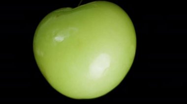 Düşme kavramı, bir Yeşil Erik Siyah Arkaplanda Dönerken Daha da Uzaklaşır. Makro Kaydırıcı.