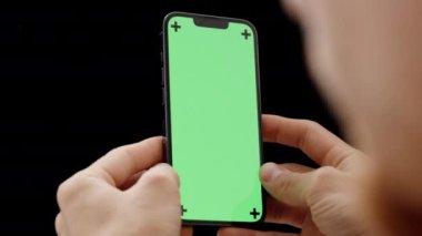 Elinde Yeşil Ekran Modeli ve İzleme İzleri ile Akıllı Telefonuna Bakan Bir Adam.
