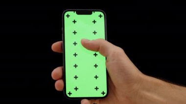 Yeşil Ekran Modeli ve İzleme İşaretli, Hareketli Akıllı Telefonun Yakın Çekimi. Bir erkek eli, internette sörf yapıyor..