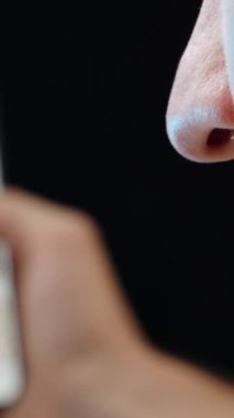 Dikey video. Fotoğrafları karıştırırken telefonunda bir şey gördükten sonra yüzünü eliyle kapayan ve kafasını sallayan bir adam.