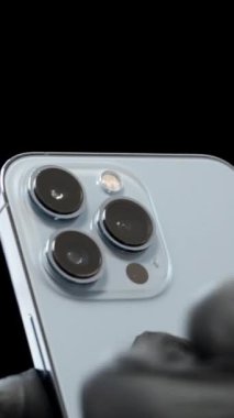 Siyah Eldivenli Eller, Smartphone 'a kamera siliyor. Onarım veya Parmak izi silme kavramı. Yakın plan.