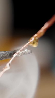 Dikey video. Teneke Solder ve Rosin, Madde Buharlaşması 'ndan duman ve buharla kaplanmış kızgın bir lehimdeki bakır tel..