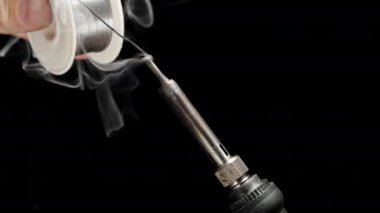 Isıtmalı uçta eriyen demir lehim için teneke merhem. Siyah Arkaplanda Zehirli Duman.