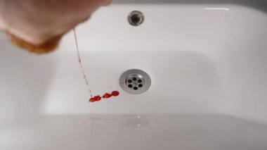 İnsan ağzından kan tükürür, ardından diş, ardından da kan damlaları..