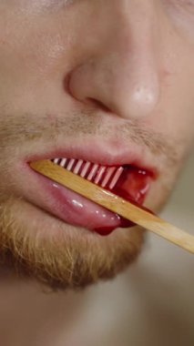 Dikey video. Sakallı adam dişlerini fırçalar, kanı fark eder, diş düşer ve ağzından kan akar. Hastalık ve Zamanlı Diş Tedavisi Konsepti.