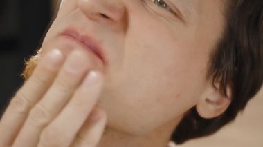 Aynanın Önündeki Kızıl Sakallı Genç Adam Burnunu Tırmalıyor ve İçeriyi Kontrol Ediyor. Ağır çekim. Yakın plan. Yüz Bakımı.