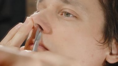 Aynanın Önündeki Kızıl Sakallı Adam Burun Kıllarını Kırpıyor, Sonucu Kontrol Etmek İçin Burnu Kaldırıyor.