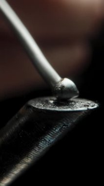Dikey video. Aşırı ısınmış ve yanmış Demir Uç 'ta Solder Erimesi, Yapışmadan Pürüzsüz Bir Küre Oluşturmak, Makro.