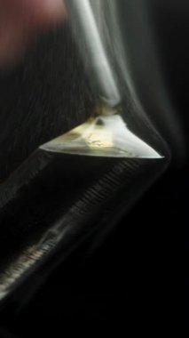 Dikey video. Eritme Girişimi Mermi Solder Kablosu Rosin damlacıkları içine lehimleme demiri, yavaş çekim makro. Acrid Duman Yükseliyor.