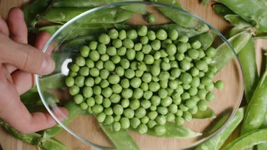 Üst manzara, temiz yeşil bezelyeleri kameraya yaklaştırmak ve tabağı sallamak, yavaş çekim.