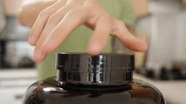 Siyah Kavanozun Yakın Çekimi Bir Adam Tarafından Kaşık Koparılırken Üzerinde Protein Tozu Var.