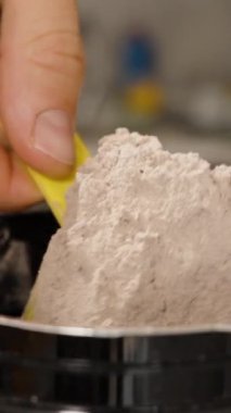 Dikey video. Adam bir kaşık dolusu Protein tozu sıçrattı, Aşırıya kaçtı ve geri kalanı korudu..