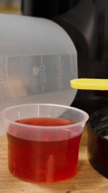 Dikey video. Toz ve Sıvı Spor İlaveleri Masanın Üzerine Porsiyonlar halinde Serildi. Doping Tamamlama Konsepti.