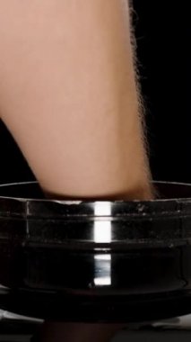 Dikey video. Protein Tozu Kaşığını Ölçen Bir Adam Tarafından Bir Titreştiriciye Dökülüyor, Siyah Arkaplanda İzole Edildi.