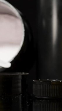 Dikey video. Kırmızı Spor İlavesi Doldurulurken Kaypak Siyah Masa 'da Protein Kaşıkları ile Çekim Yapıyor. Antrenman Öncesi Titreşim Hazırlama.