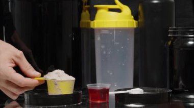 Spor malzemeleri ve vitaminler masaya konur, bir adam alınmaması gerekenleri gösterir ve küçük bir kaşık beyaz toz seçer. Tüm İlaveler Sağlıklı Değil.
