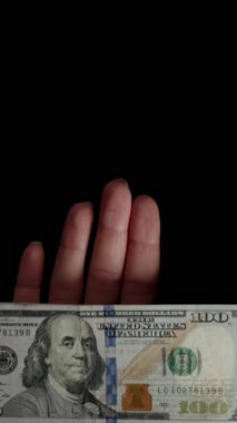 Dikey video. Bir yığın dolar teker teker elden uçup gidiyor. Harcanmış para, her zaman parasız kalma ve boşa harcama kavramı..
