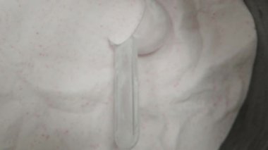 Kamera, beyaz kreatin tozuyla dolu bir konteynırdan tam ölçü kaşığıyla yükseliyor. Macro Dolly.