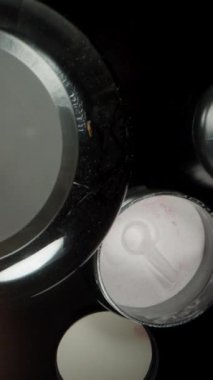 Dikey video. Üst Manzara, masada bir sürü katkı maddesi ve spor ürünü, bir kaşıkla protein tozunu karıştırmak. Dolly Kaydırıcı, Yakın plan.
