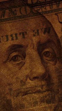 Dikey video. Franklin 'in Yüzlerce Dolar Üzerinde Portresi Hafifçe ve kısmen Aydınlatılmış Filigran ve Güvenlik Özellikleriyle.