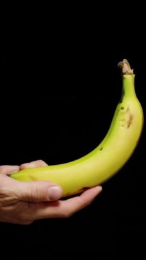 Dikey video. El Muzu Çevirir Havaya Fırlatırken Yavaş Hareket, Kara Arkaplanda İzole Edilmiş.