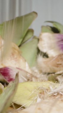 Dikey video. Doğranmış Enginar Masaya Dağılmış, Yakın Çekim. Yavaş Hareket.