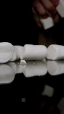 Dikey video. Beyaz şekerlemeler Kara Masa 'ya atıldı, Karanlıktan El Çıktı.