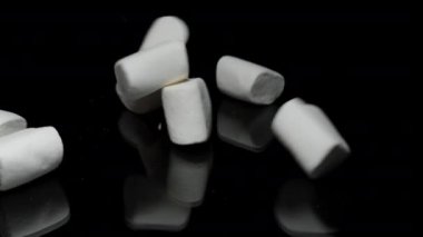 Beyaz Marshmallow Yığını Siyah Yansıtıcı Masa 'ya Düşüyor, Yavaş Hareket. Şeker ve Şeker Zararı kavramı.