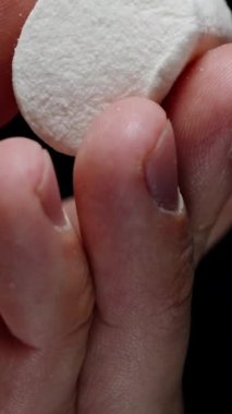 Dikey video. Marshmallow 'un Siyah Bir Arkaplana Karşı El sıkışması. Yumuşak Şekerli Doku.