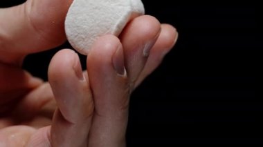 Marshmallow 'un Siyah Bir Arkaplana Karşı El sıkışması. Yumuşak Şekerli Doku.