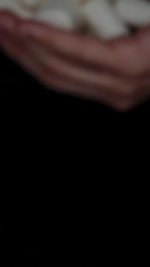 Dikey video. Erkek ayağında beyaz şekerli şekerlemeler. Şeker Bağımlılığı. Onları sana sunuyorum..
