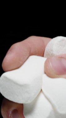 Dikey video. El Açgözlülükle Şeker Şekerleme Sıkar, ama Sonra Döker. Siyah Arkaplana Karşı Yavaş Hareket, Şekerleri Reddetme Kavramı.