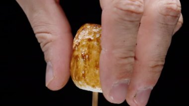 Yanmış Marshmallow 'un Karamel Kabuğu Elle Soyulmuş, İçindeki Yumuşaklığı Ortaya Çıkartıyor.