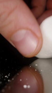 Dikey video. Yumuşak Yumuşak Şekerlemeler Erkek El tarafından sıkılmış, Sağlıksız Tatlı Yiyecekler. Dolly Kaydırıcı, Yakın plan.