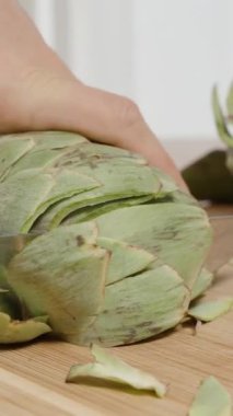 Dikey video. Tahta tahtada bir enginar kesmek, Sağlıklı Beslenme.