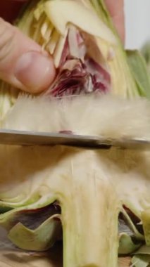 Dikey video. Bir enginarın İçindeki Kabarık Saçlar, Onları Bıçakla Kesmek ve Yakın Çekim Göstermek.