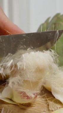 Dikey video. Kıllı Saçlar, Enginar Çiçeğinin İçi, Beyaz Parça 'yı Bırakırken Kesmek.